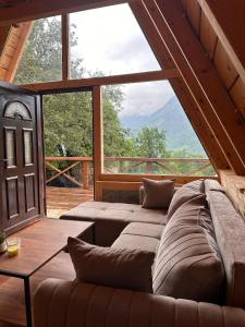a large couch in a room with a large window at Retreat Komovi in Andrijevica