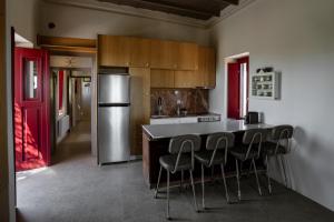 a kitchen with a bar with chairs and a refrigerator at Kirkinezi Kythira in Kythira