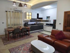 a living room with a couch and a table and a kitchen at Mon Nid d'Or ABIDJAN CI in Abidjan