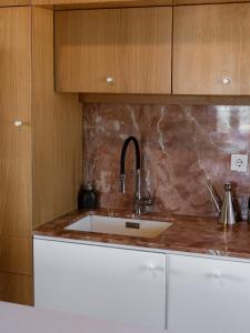 a kitchen with a sink and wooden cabinets at Kirkinezi Kythira in Kythira +62 photos