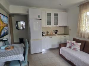 a living room with a couch and a kitchen at Blue Serenity in Nea Vrasna