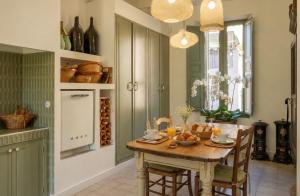 a kitchen with a wooden table and chairs and a kitchen with a window at Maison Aimé in La Motte