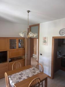 a dining room and kitchen with a table and a chandelier at Appartamento Ares in Misano Adriatico