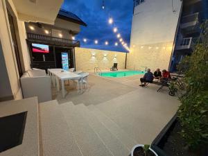 two people sitting on a balcony of a building with a pool at New Venus in Curtea de Argeş