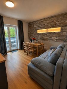a living room with a couch and a table at Ferienwohnung Wendelstein in Kiefersfelden +16 photos