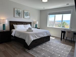 a bedroom with a large bed and a window at Shannon Heights B&B in West Kelowna