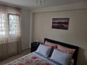 a bedroom with a bed with pink and white pillows at Blue Serenity in Nea Vrasna