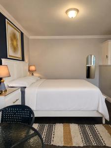 a bedroom with a large white bed and a chair at Inn At Juzani Boutique Hotel in Lambeau +195 photos