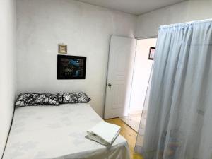a small bedroom with a bed and a door at Alojamiento Wilkenia in Ochoa