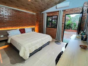 ein Schlafzimmer mit einem Bett und einer Ziegelwand in der Unterkunft Hotel Suites Bambú in Minga Guazú + 18 Fotos