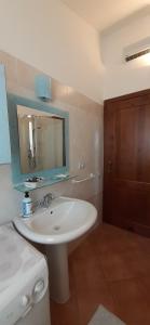 a bathroom with a white sink and a mirror at Casa Signorile in Villasimius +16 photos