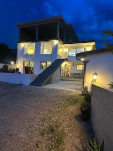 a large white house with stairs in front of it at night at Irma Haus in Jadranovo