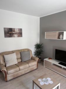 a living room with a couch and a tv at Appartamento Ares in Misano Adriatico