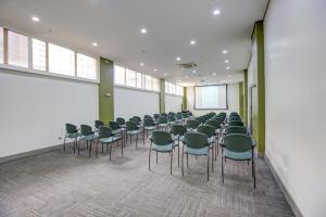 a room with a bunch of chairs and a screen at Quality Suites Alphaville in Barueri