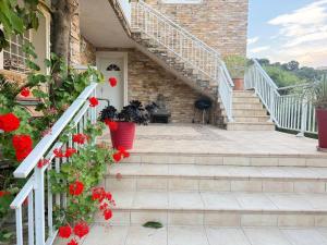 a house with red flowers on the stairs at "U Monte Rossu" – T2 paisible | by Efficios in Petreto-Bicchisano +8 photos