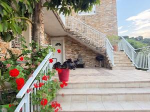 a house with red flowers on the stairs at "U Monte Rossu" – T2 paisible | by Efficios in Petreto-Bicchisano
