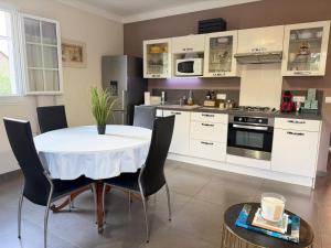 a kitchen with a table and chairs in a room at "U Monte Rossu" – T2 paisible | by Efficios in Petreto-Bicchisano
