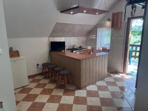 a kitchen with a counter and bar with stools at Domek u Moni Kaszuby in Sulęczyno