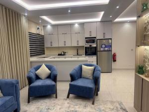 a kitchen with two blue chairs and a refrigerator at فلل دوبلكس - جدة in Jeddah