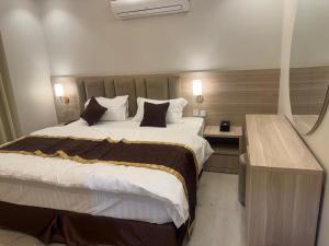 a bedroom with a large bed and a desk at فلل دوبلكس - جدة in Jeddah
