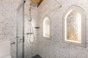 a bathroom with a shower and two windows at Krasna Hiška - Authentic Heritage Home in Sežana +26 photos