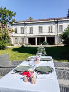 a white table with plates and glasses on it at MaVa' Country House in Castelnuovo Bocca dʼAdda