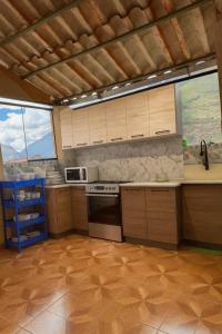 a kitchen with wooden cabinets and a stove top oven at Hospedaje Shalom in Pisac
