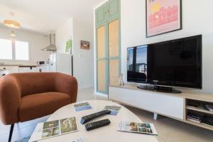 a living room with a television and a chair at Maison Lafitte-Vigordane in Lafitte-Vigordanne