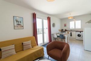 a living room with a couch and a kitchen at Maison Lafitte-Vigordane in Lafitte-Vigordanne