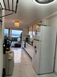 a kitchen with a white refrigerator and a tile floor at Irma Haus in Jadranovo