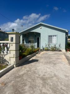 a blue house with a driveway in front of it at Pleasant 1 bed room in Discovery Bay