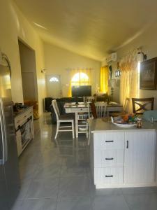 a kitchen and living room with a table and chairs at Pleasant 1 bed room in Discovery Bay