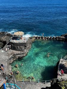 people swimming in a swimming pool in the ocean at Casita Drago in Santa Cruz de la Palma