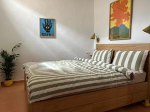 a bedroom with a bed with a striped comforter at Casita Drago in Santa Cruz de la Palma