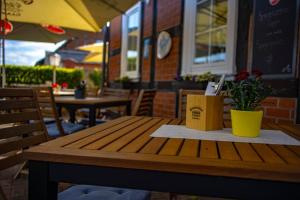 ein Holztisch mit einer Kiste und einer Pflanze darauf in der Unterkunft Restaurant und Pension Zur Wildgans in Arendsee