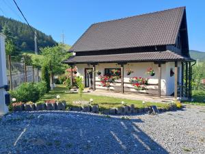 a small house with flowers in front of it at Green Valley Guesthouse in Izvoru Mureşului