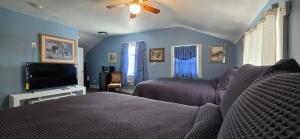 a bedroom with two beds and a flat screen tv at Niagara Historic Inn in Lockport