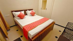 a bedroom with a bed with red and white pillows at Sivam Villa-Kovalam in Covelong