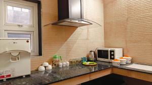 a kitchen with a counter top with a microwave at Sivam Villa-Kovalam in Covelong