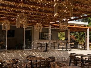 a patio with tables and chairs and chandeliers at Abelia Boutique Rooms in Tsilivi