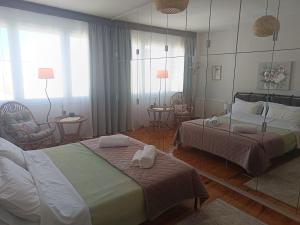 ein Schlafzimmer mit zwei Betten, Stühlen und einem Spiegel in der Unterkunft Mountain Icon in Florina