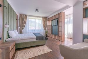 ein Schlafzimmer mit einem Kingsize-Bett und einem Sessel in der Unterkunft Vila Core in Rucăr