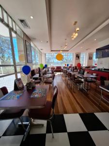a restaurant with tables and chairs and windows at Quality Suites Alphaville in Barueri