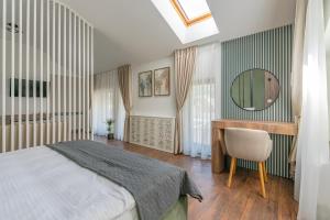 ein Schlafzimmer mit einem Bett, einem Schreibtisch und einem Spiegel in der Unterkunft Vila Core in Rucăr