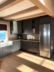 a kitchen with stainless steel appliances and a wooden ceiling at Ørnereiret in Torvetjørn