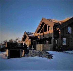 a log home with snow in front of it at Ørnereiret in Torvetjørn