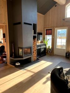 a living room with a stove and a fireplace at Ørnereiret in Torvetjørn