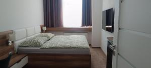 a small bedroom with a bed and a television at Tami Apartman Hviezdoslavova 2, Liptovsky Mikulas, Private Parking in Liptovský Mikuláš