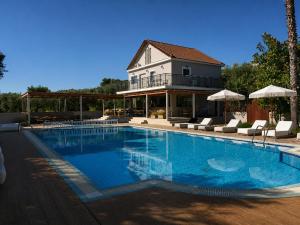 a swimming pool in front of a house at Abelia Boutique Rooms in Tsilivi
