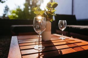 two wine glasses on a wooden table with a candle at Black Forest Living am Marktplatz in Freudenstadt